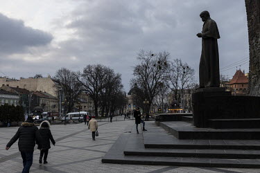 People walk past the Taras Shevchenko Monument in downtown Lviv on a Thursday evening.