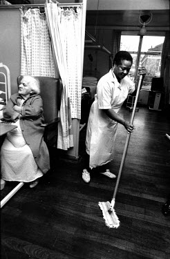 Nancy, an auxiliary health worker, cleans the floor on a hospital ward.