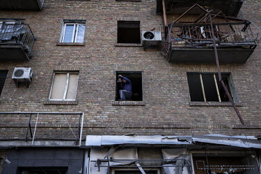 A man repairs windows destroyed by Russian bombing, some said from a falling piece of a missile, in Kurenivka, western Kyiv.