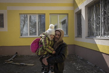 A man carries his daughter having just been evacuated from the frontline town of Irpin. As heavy fighting continued in the town of Irpin nearby, a steady stream of tired, mainly elderly, civilians wer...