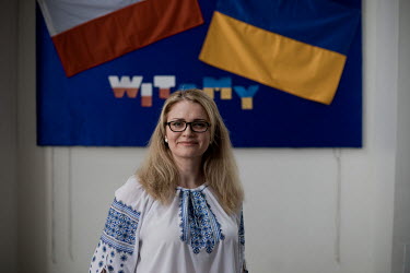 Ukrainian teacher Zoryana from Lviv, who fled the war in March 2022, next to a 'welcome' sign with the Polish and Ukrainian flags at public primary school number 81 where around 10% of the school's pu...