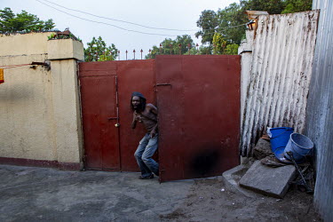Artist, Freddy Tsimba at the gates of his workshop. He says he finds his inspiration in the suffering experienced by many communities in his country. An advocate for disarmament, much of his art is fa...