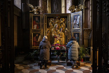 Women pray at the Church of the Most Holy Apostles Peter and Paul.