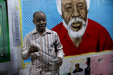 Congolese artist Cheri Samba painting at his house in Ndjili.