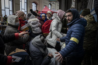 Volunteers help people board a train bound for Poland from Lviv station.