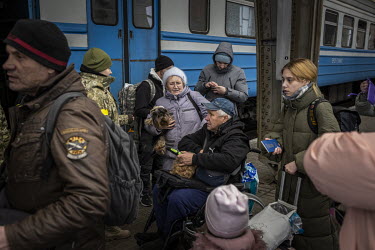 People show their documents to the military before boarding a train bound for Poland from Lviv station.