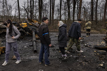 Civilians and Ukrainian soldiers examine the burnt out remnants of as many as nine Russian tanks and armoured fighting vehicles litter a forested road leading out of the town of Dmytrivka. Ukrainian s...