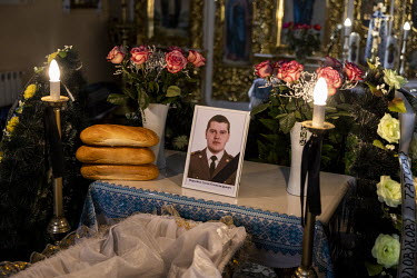 A photograph of Senior Sergent Yevhen Verveyko sits beside his coffin during the funeral of the Ukranian National Army soldier who was killed fighting against Russian forces.