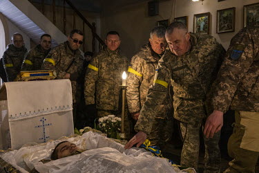 Military commrades file past the open coffin during the funeral ceremony for Senior Sergent Yevhen Verveyko of the Ukranian National Army, who was killed fighting against Russian forces.