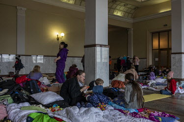 Women and children, many of them from the besieged city of Kharkiv, rest in a waiting hall at Lviv train station.