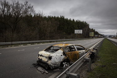 A burnt out civilian car on the highway that leads west out of Kyiv. Ukrainian soldiers said that a couple and their young child had died after their car was hit by a Russian shell.