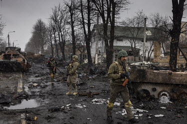 Ukrainian soldiers walk past destroyed armoured vehicles. In this area the damage had allegedly been done after Ukrainian forces had targeted a Russian convoy, using Turkish made attack drones, in the...