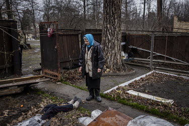 Antonina Pomazanko (76) looks down at the half buried body of her daughter, Tetiana (56), which lies virtually where she had fallen after being shot by Russian forces when they entered Bucha on the 27...