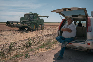 Jose Maria Osorio Alatorre, chairman of the Production Societies of Southern Sonora (USPRUSS), sits in the shade of his vehicle while he overseas the harvesting of his wheat fields. The local farmer f...