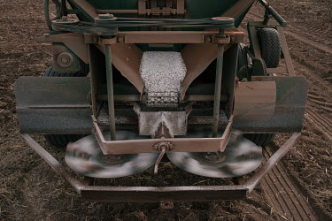 The discs of a fertiliser spreader spin before scattering urea, a nitrogenous compound fertiliser, across a dry field where wheat will be planted. Around October, when the land is dry, many local farm...