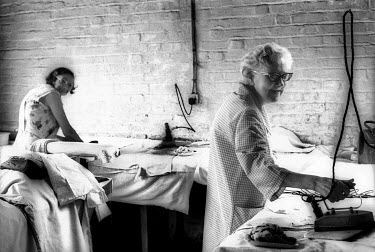 Workers ironing clothes at the West London Pages Laundry.