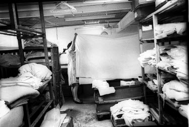 A worker folding sheets at the West London Pages Laundry.