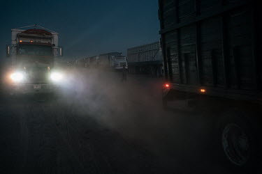 A driver walks between a queue of trucks waiting to deliver wheat for export to Ferropuerto de Sonora, a company dedicated to services for cargo transportation. The Yaqui Valley is a wheat-producing r...