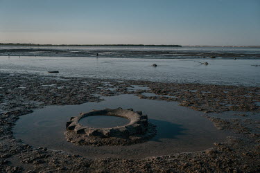 A tractor tyre lies beside an irrigation drain which dischargers into the Tobari Bay. The bay has pollution and silting problems due to the discharge from 267 miles of agricultural drains that empty i...
