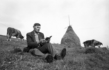 A cow herder reading a Bible in the Carpathian Mountains north of Slavsko. During Stalin's rule possession of a Bible was punishable by deportation to the gulags. Until the approach of independence th...