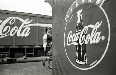 A woman wearing traditional Ukrainian dress walking past Coca Cola concessions on Kiev Day, an annual event held to celebrate the heritage of Ukraine's capital.