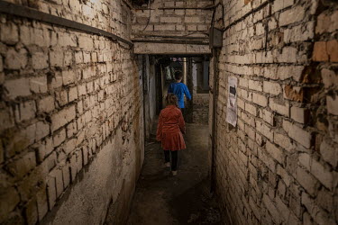 Children walk through an underground bunker and bomb shelter.