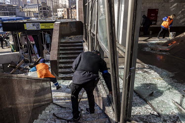 People clearing debris at the site of a Russian missile strike that damaged the Lukyanivska metro station.