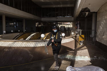 A policeman helps clear shards of glass from the site of a Russian missile strike that damaged the Lukyanivska metro station.
