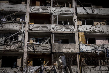 A man stands on the destroyed balcony of his apartment, after a Russian missile, intercepted by Ukrainian air defences, hit the building in northern Kyiv.