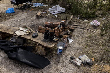 An abandoned Russian checkpoint, near a blown-up bridge in the Exclusion Zone, which was littered with items of clothing, cooking materials and empty ration packs bearing the Russian military emblem....