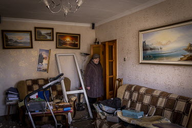 Kateryna Pomomarenko looks on in shock at the living room of her destroyed apartment. Part of a Russian missile, intercepted by Ukrainian air defences, hit her building in northern Kyiv.