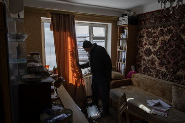 Viktor Chernatevich (75) examines his heavily damaged apartment the day after the block had been hit by a Russian missile strike.