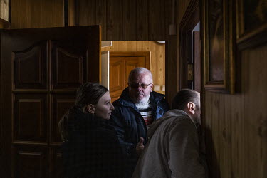 Oleksandr Ponomarenko examines the destruction in his apartment with his son and daughter in law. Part of a Russian missile, intercepted by Ukrainian air defences, hit their building in northern Kyiv.