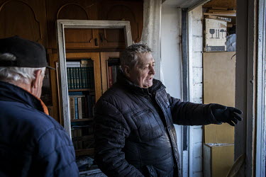 Viktor Chernatevich (75) examines his heavily damaged apartment the day after the block had been hit by a Russian missile strike.