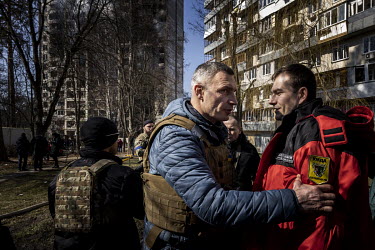 The mayor of Kiev, former heavyweight boxing champion, Vitali Klitschko, speaks with a member of the emergency services at the scene of a burning apartment block that was hit by Russian shelling earli...