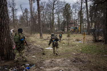 Volunteer fighters with the Territorial Defence Forces in Bucha, search the grounds of a children's sanatorium, that had been used as a base by Russian soldiers, for mines and bodies. The bodies of fi...