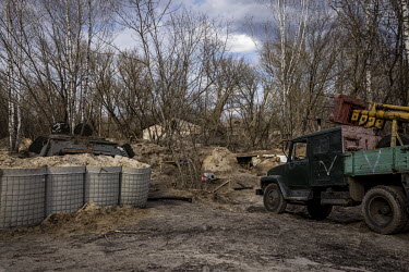 An abandoned Russian vehicle, bearing the letter 'V', at a checkpoint on a road in the Exclusion Zone leading to the Chernobyl power plant. Russian soldiers appeared to have dug into and built entrenc...