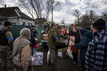 Vita Zaverukha, Oleksiy Serediuk and Vitaliy Chorny, members of the Bratstvo Battalion, a fighting group part of the Territorial Defence Forces, deliver humanitarian aid to civilians in the village of...