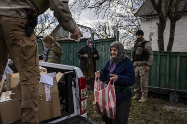 Vita Zaverukha, Oleksiy Serediuk and Vitaliy Chorny, members of the Bratstvo Battalion, a fighting group part of the Territorial Defence Forces, deliver humanitarian aid to civilians in the village of...