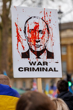 A placard with an image of Putin and the slogan 'War Criminal' during a solidarity protest in Whitehall against the Russian invasion of Ukraine. The protest brought together Ukrainians, Russians, Uygh...