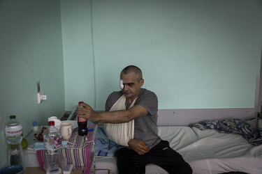 Vitaliy (42) rests on his hospital bed while recovering from various injuries. Several weeks earlier Vitaliy, a mechanic, was driving on a road south of Chernihiv fetching supplies of flour from a far...
