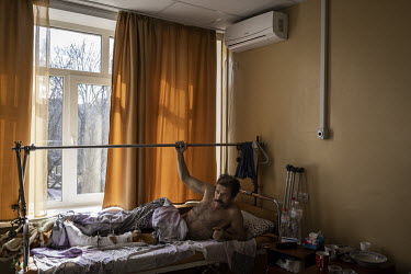 Oleg (61) recuperates in a hospital having been shot in the leg three times by Russian forces in Irpin.