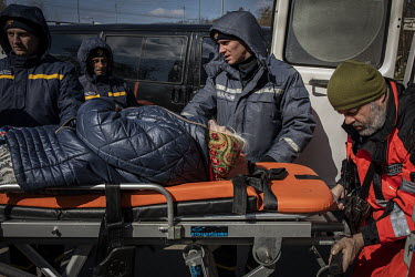 A sick woman is moved to an ambulance as a steady stream of civilians arrived in minivans and ambulances at an aid station in north west Kyiv, having being evacuated from the besieged town of Irpin. T...