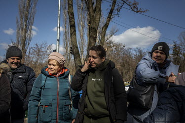 A woman wipes away a tear as a steady stream of civilians arrived in minivans and ambulances at an aid station in north west Kyiv, having being evacuated from the besieged town of Irpin. They were car...
