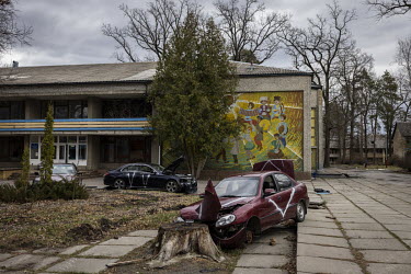 Destroyed and abandoned cars, sprayed-painted with the letter 'V', outside a children's sanatorium that had been used as a base by Russian soldiers. The bodies of five people were found, with their ha...