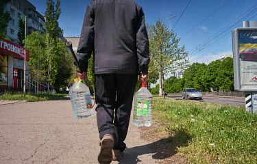 An elderly man collecting drinking water from a tanker. The city has had no drinking water since 12 April 2022 due to heavy Russian bombardment which has destroyed supply infrastructure.