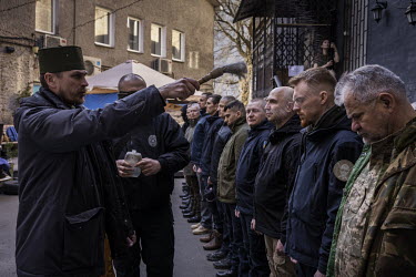 Volunteers from the group 'Free Ukraine', now part of the Kyiv Territorial Defence Forces, are blessed by a priest, having graduated from the initial phase of training.