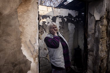 Svetlana Ilyuhina looks at the burnt out remains of her home after it was struck in a Russian multiple rocket attack in the Nyvky district of western Kyiv early that morning.