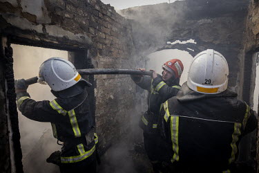 Fire fighters battle to put out a fire at the home of Vladimir Okremenko and his sister Svetlana Ilyuhina, after it was struck in a Russian multiple rocket attack in the Nyvky district of western Kyiv...