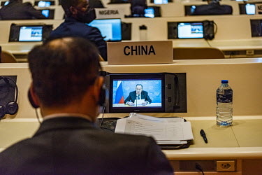 A Chinese diplomat watches as Russian Foreign Minister Sergei Lavrov addresses the Conference on Disarmament at the UN through a video speech. He had been due to address the conference live, but cance...